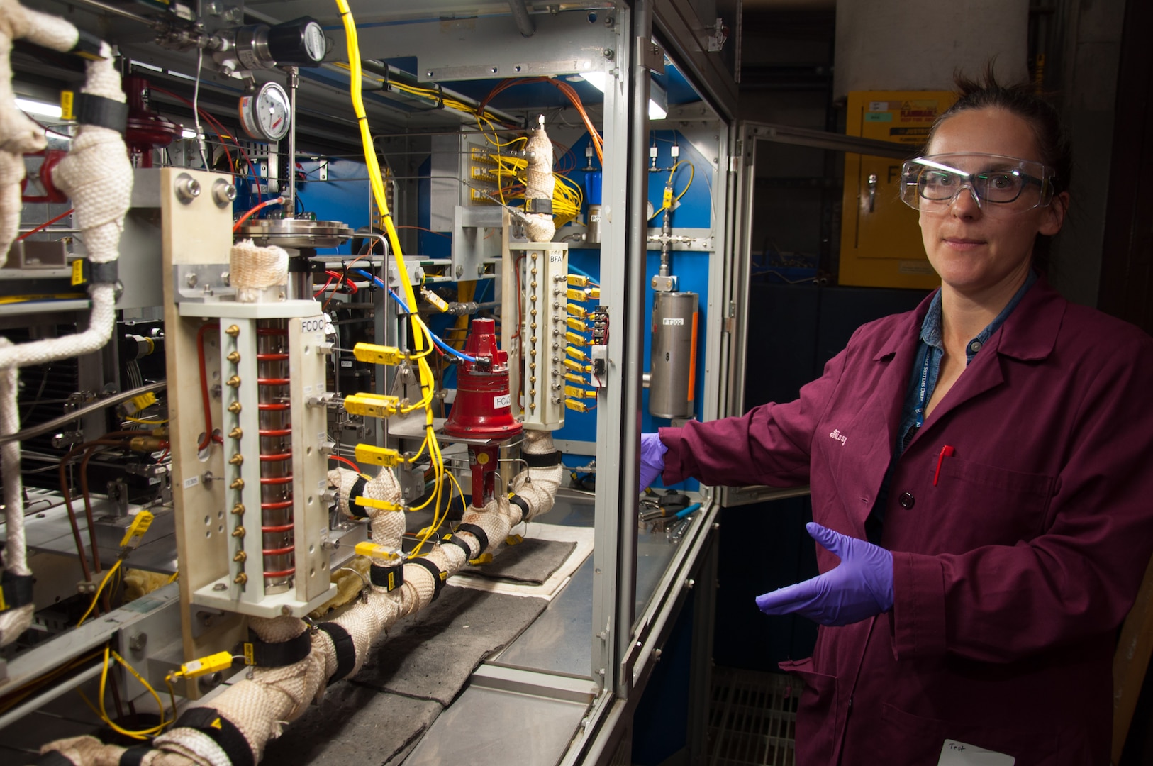 Milissa Griesenbrock, Air Force Research Laboratory Fuels and Energy branch co-lead for High Impact Technology 1 - Fuel Science and research chemist, gives a tour of a fuel system simulator. The FSS simulates time and temperature heat loads along the flow pathway of jet fuel in order to investigate impacts of different fuel chemistries on real and simulated hardware. (U.S. Air Force photo/John Harrington)