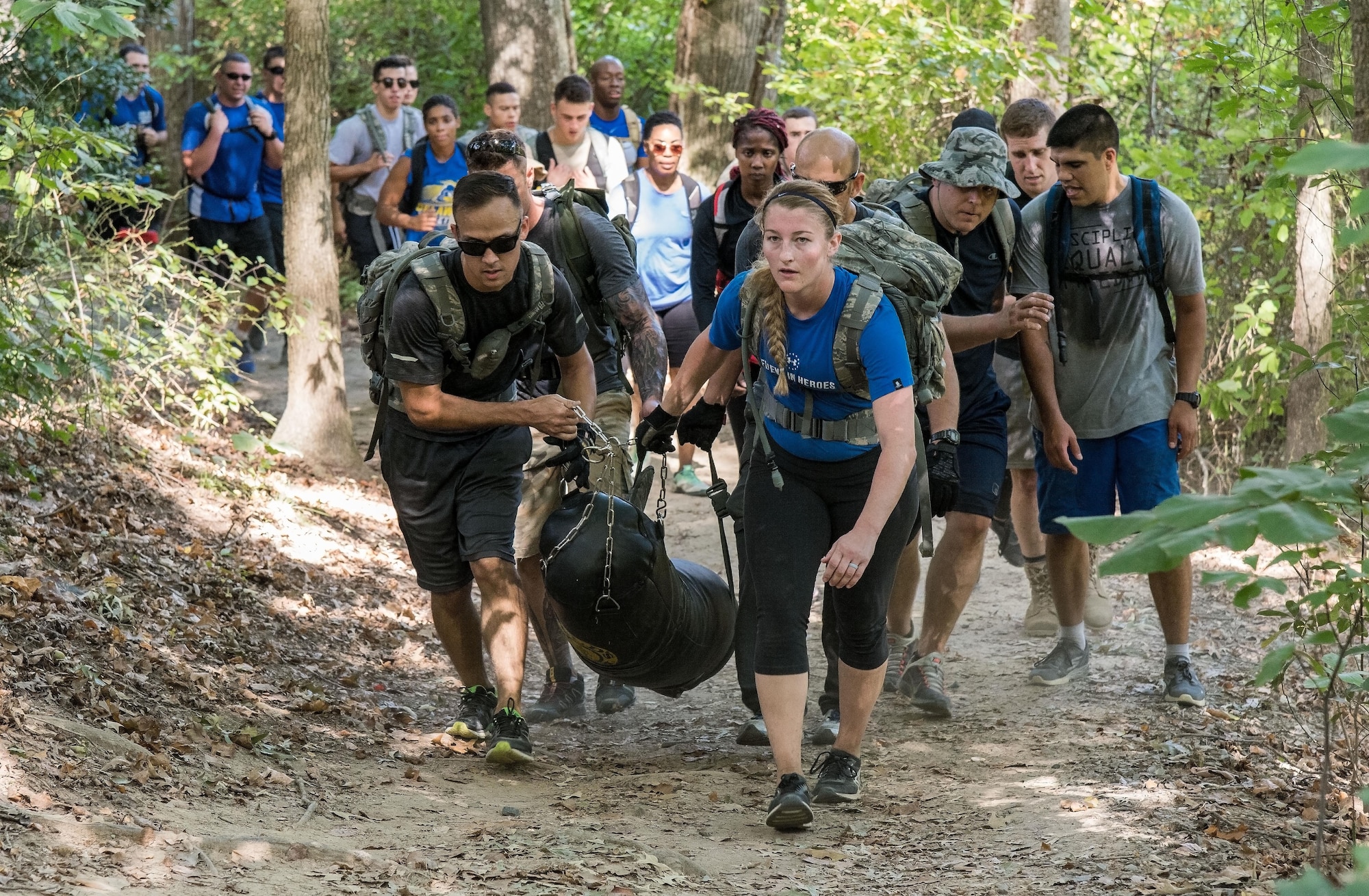 Working in teams, participants in the 2017 GORUCK Light Challenge carried a punching bag while completing three laps on the hiking trail Oct. 6, 2017, at Brecknock Park in Camden, Del. Participants completed the laps while carrying their rucksack, chains and a punching bag. (U.S. Air Force photo by Roland Balik)