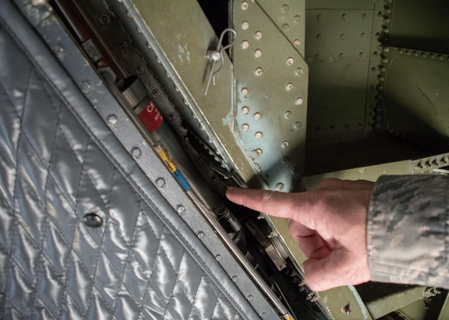 Master Sgt. D.J. Little, a 94th Maintenance Squadron hydraulic technician, points out the small space that houses the actuator on a C-5M Super Galaxy at Dobbins Air Reserve Base, Ga. Oct. 6, 2017. Little worked with technicians from Dover Air Force Base, Dela. on creating custom-sized hydraulic hoses to bypass the actuator so that it could be replaced. The actuator is needed to open and close the visor of the aircraft so that cargo can be offloaded. In this case, the cargo included communication equipment for Puerto Rico. (U.S. Air Force photo/Staff Sgt. Andrew Park)