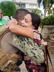 A resident hugs a Coast Guard member after he delivered food and water to the people of Moca.