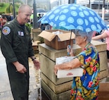 Coast Guard Cmdr. Jeremy Anderson delivers a box of food and water to a resident of Moca.
