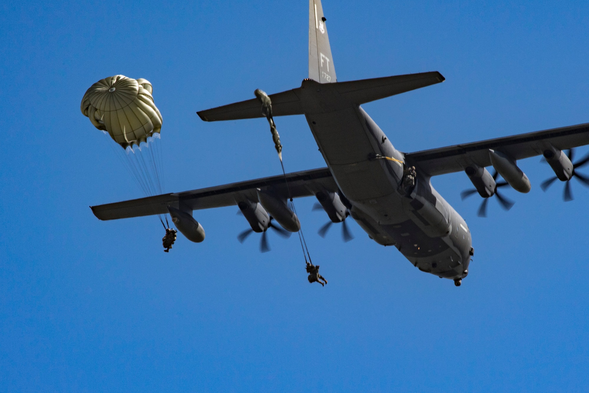 Members of the 820th Base Defense Group exit an HC-130J Combat King II during a static-line jump, Oct. 3, 2017, at the Lee Fulp drop zone in Tifton, Ga. During a static-line jump, the jumper is attached to the aircraft via the ‘static-line’, which automatically deploys the jumpers’ parachute after they’ve exited the aircraft. (U.S. Air Force photo by Airman 1st Class Daniel Snider)