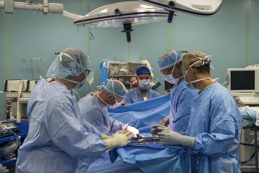 Sailors perform a surgical operation aboard a ship.