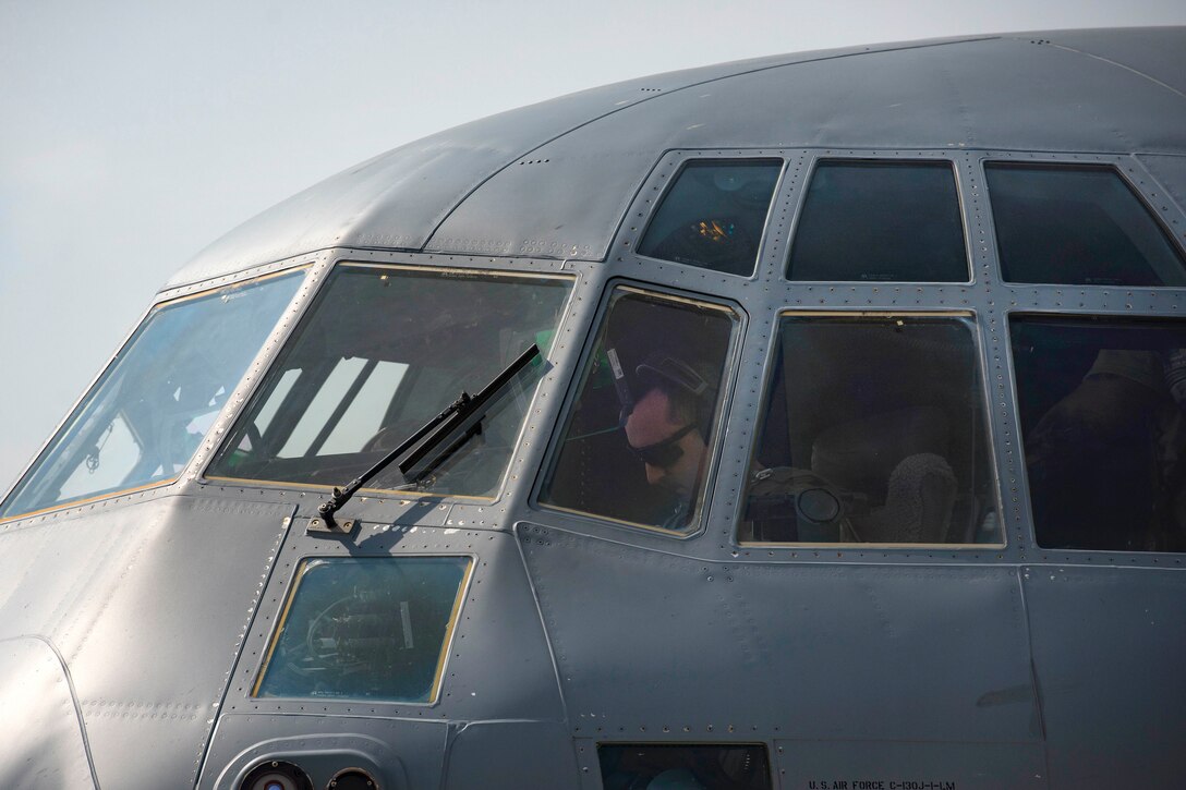 An Air Force pilot prepares a C-130J Super Hercules aircraft before takeoff.
