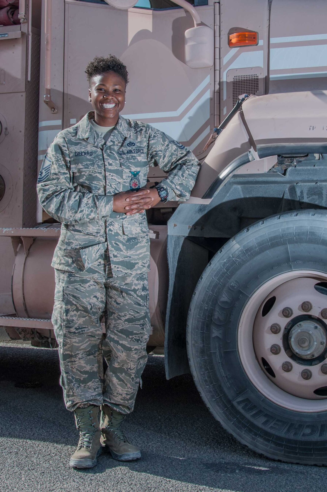 Master Sgt. Mendy Dillard poses for a portrait beside a fire truck at an undisclosed location in Southwest Asia Wednesday, 11 October 2017. Dillard is celebrating her 11th year serving the Air Force as a firefighter. (U.S. Air Force photo by Master Sgt. Eric M. Sharman)