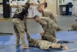 Instructor provides guidance to a group of Soldiers practicing hand-to-hand combat.