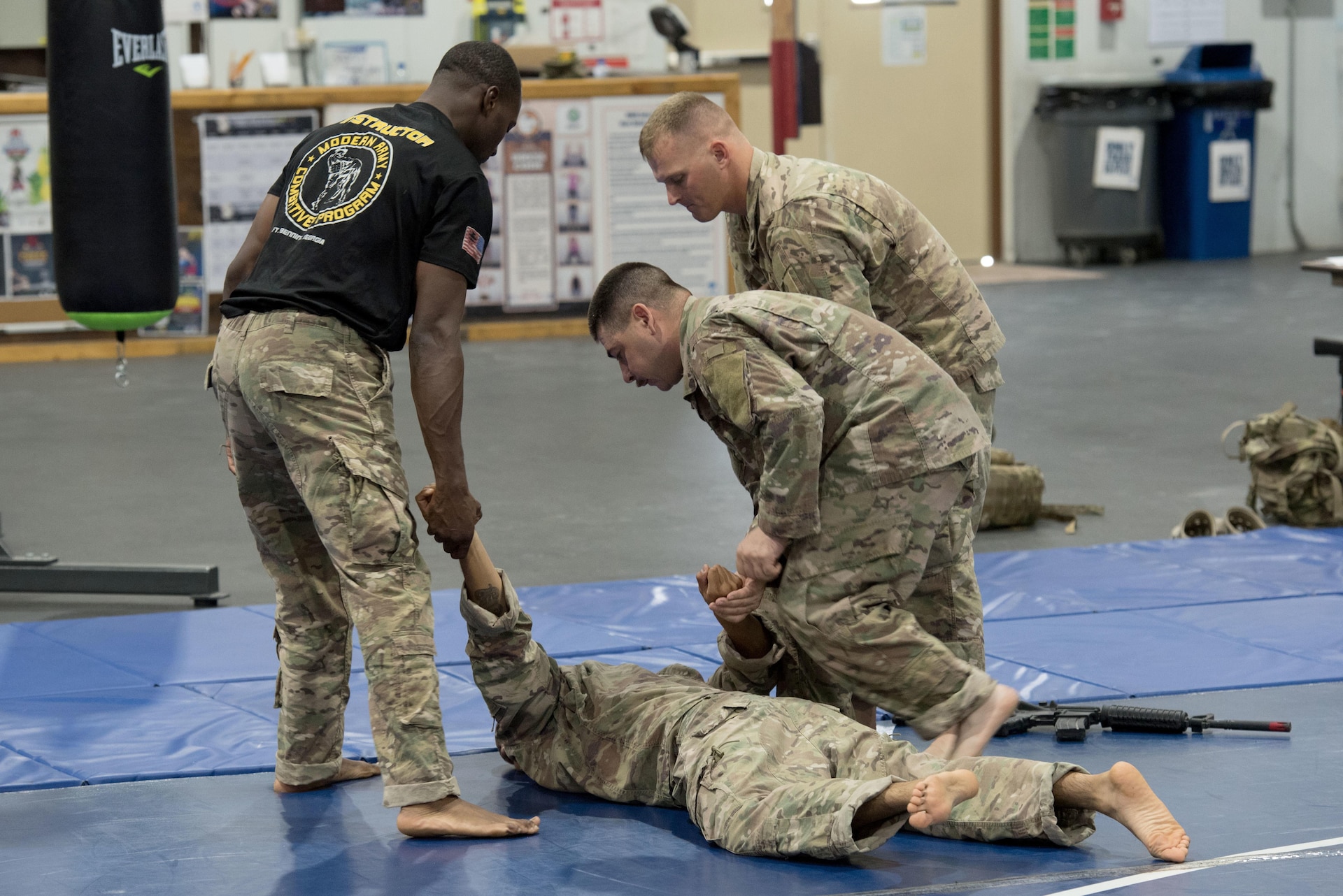 Instructor provides guidance to a group of Soldiers practicing hand-to-hand combat.