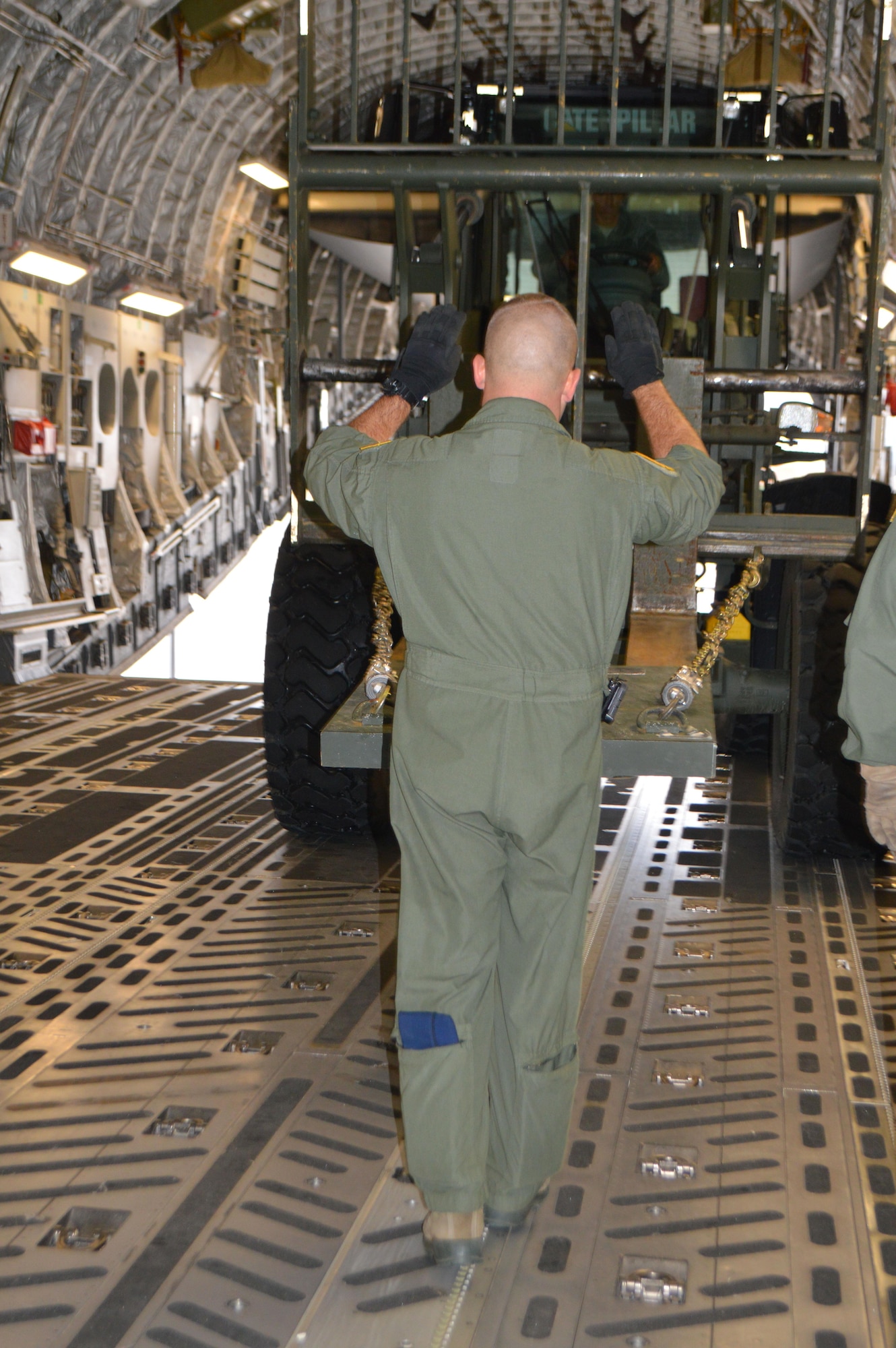 Tech. Sgt. Blake Lemaster, loadmaster, 89th Airlift Squadron out of Wright-Patterson Air Force Base, Ohio, guides a 10K forklift driven by Airman 1st Class Curtis Turner, aerial port airman, 21st Logistics Readiness Squadron in a C-17 Globemaster III aircraft Sept. 29 at the Fort Carson Arrival/Departure Air Control Group. Approximately 150 Fort Carson 4th Sustainment Brigade, 4th Infantry Division Soldiers deployed to Puerto Rico and the Virgin Islands to support Federal Emergency Management Agency and relief operations on the island after it was devastated by Hurricane Maria. (U.S. Army photo by Dani Johnson)