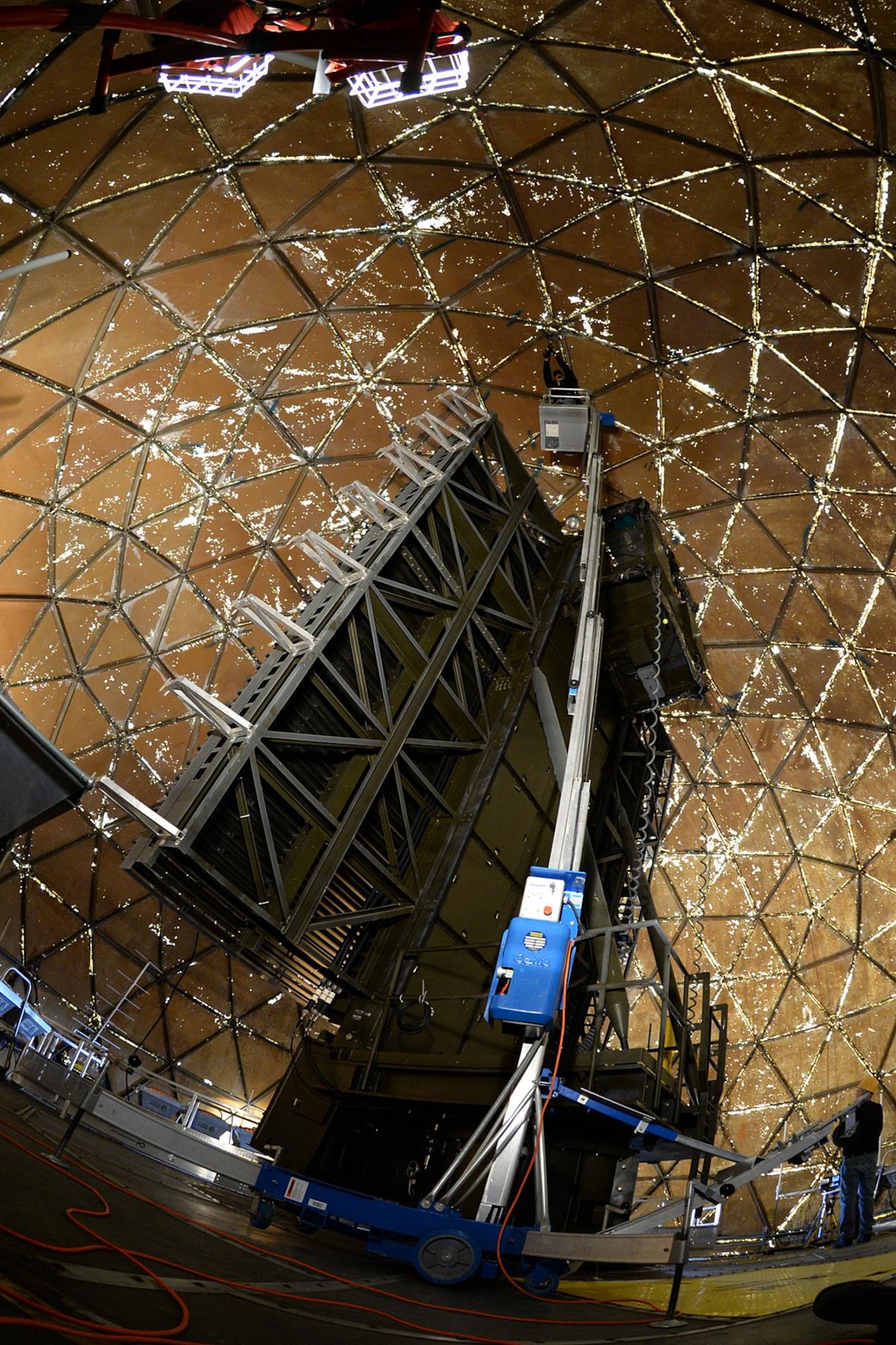 Justin Cevering, 526th Electronics Maintenance Squadron plastic fabricator inspector, uses a "man lift" to reach the top of the 50-foot-high radome structure on Sep. 26, 2017, at Cape Romanzof, Alaska. Bolts holding the structure together have to be checkedand often requires the use of ladders and lifts to reach them. (U.S. Air Force photo by Alex R. Lloyd)