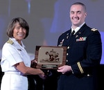 Vice Adm. Raquel Bono, Director, Defense Health Agency, presents Maj. (Dr.) Steven Schauer, of the U.S. Army Institute of Surgical Research at Joint Base San Antonio-Fort Sam Houston. with the 2017 Military Health System Research Symposium award for Outstanding Research Accomplishment (military/individual) Aug. 26.