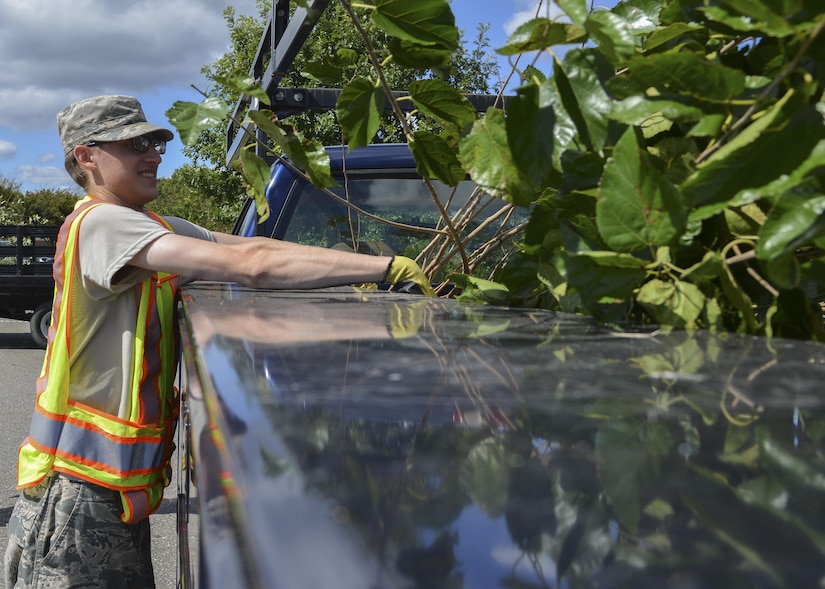 U.S. Air Force Airman 1st Class Greg, Base Appearance Team member, throws cut branches in the back of a truck at Joint Base Langley-Eustis, Va., Oct. 2, 2017.