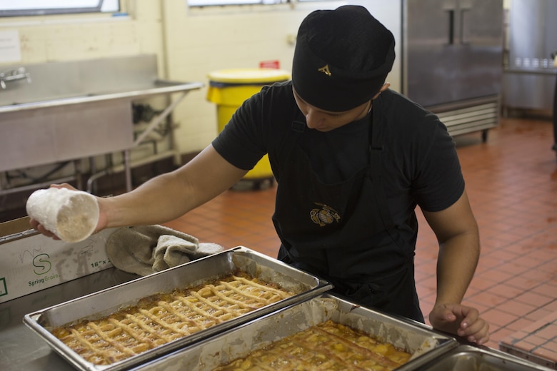 Lance Cpl. Cynthia JaretziCruz, a food service specialist with Headquarters Battalion, Marine Corps Base Hawaii (MCBH), and the winner of the “Chef of the Year” competition at Anderson Hall, MCBH, seasons an apple dessert, Oct. 4, 2017. The competition pitted each winner or runner-up of the Chef of the Quarter cook-off against each other in a series of evaluations including a written test, display/presentation, and creativity. (U.S. Marine Corps photo by Lance Cpl. Luke Kuennen)