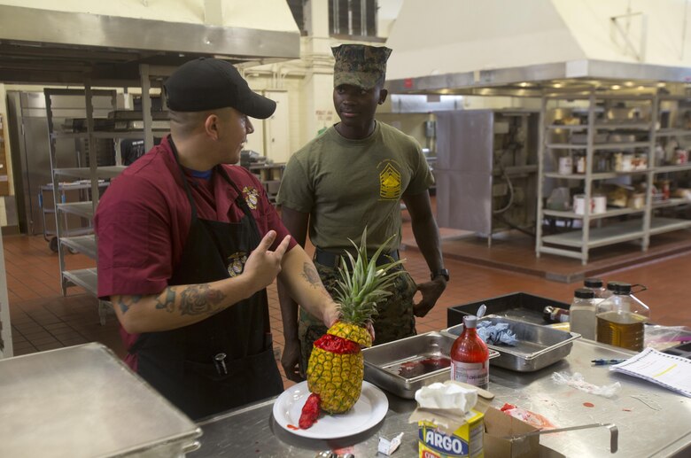 Sgt. Ewhondens Kenel, an assistant mess chief with Headquarters Battalion, Marine Corps Base Hawaii (MCBH), observes the cooking portion of the “Chef of the Year” competition at Anderson Hall, MCBH, Oct. 4, 2017. The competition pitted each winner or runner-up of the “Chef of the Quarter” cook-off against each other in a series of evaluations including a written test, display/presentation, and creativity. (U.S. Marine Corps photo by Lance Cpl. Luke Kuennen)