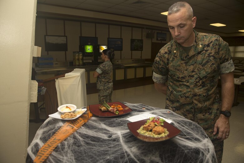 Maj. Chad Tidwell, the Marine Corps Forces, Pacific, food service officer, inspects the display of Lance Cpl. Cynthia JaretziCruz, a food service specialist with Headquarters Battalion, Marine Corps Base Hawaii (MCBH), and the winner of the “Chef of the Year” competition at Anderson Hall, MCBH, Oct. 4, 2017. The competition pitted each winner or runner-up of the “Chef of the Quarter” cook-off against each other in a series of evaluations including a written test, display/presentation, and creativity. (U.S. Marine Corps photo by Sgt. Ricky Gomez)