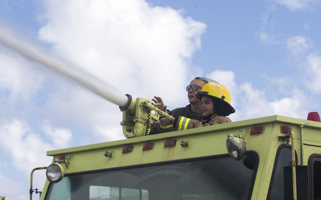 Maddox Hyde sprays water from an Aircraft Rescue and Firefighting (ARFF) truck during a tour of Marine Corps Base Hawaii, (MCBH) Sept. 27, 2017. The Hyde family was led on tours of Marine Corps Air Station Kaneohe Bay, ARFF, and took part in various simulators across MCBH as part of Maddox’s wish to see where his father served before he begins his next cycle of cancer treatment. (U.S. Marine Corps photo by Lance Cpl. Luke Kuennen)