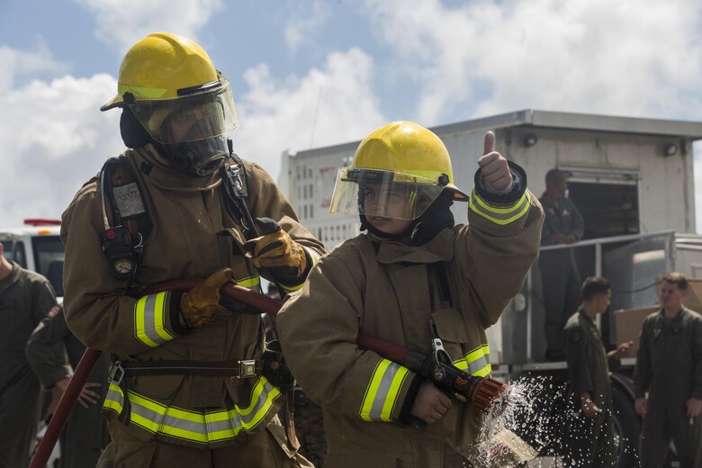 Maddox Hyde gives the thumbs-up to aircraft rescue firefighters (ARFF) during a tour of Marine Corps Base Hawaii, (MCBH) Sept. 27, 2017. The Hyde family was led on tours of Marine Corps Air Station Kaneohe Bay, ARFF, and took part in various simulators across MCBH as part of Maddox’s wish to see where his father served before he begins his next cycle of cancer treatment. (U.S. Marine Corps photo by Lance Cpl. Luke Kuennen)