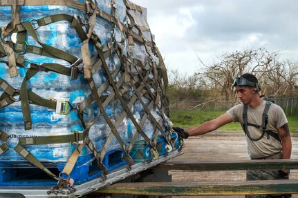 Senior Airman Cody Alverson guides a pallet of water onto a Halvorsen K-loder at Aguadilla.