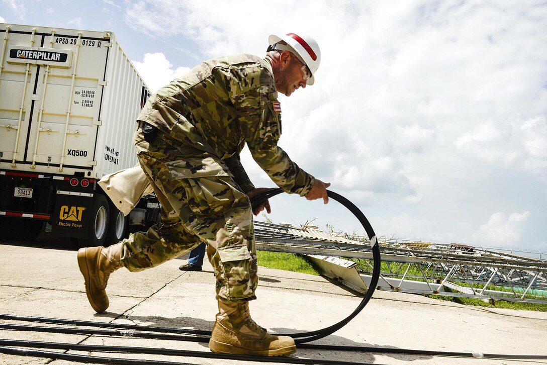 Army Sgt. Jesse Johnson prepares a cable to be used to install a FEMA generator.