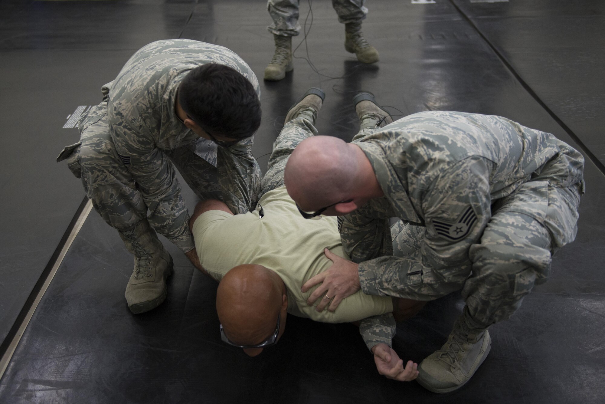 Chief Master Sgt. Elvin Young, 374th Airlift Wing command chief, is guided to a mat after getting tased during a 374th Security Forces Squadron less-lethal weapons demonstration, Oct. 11, 2017, at Yokota Air Base, Japan.