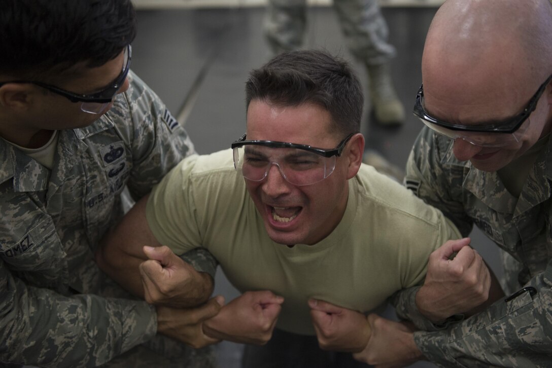 Col. Sergio Vega, 374th Airlift Wing vice commander, is guided to a mat while being tased during a 374th Security Forces Squadron less-lethal weapons demonstration, Oct. 11, 2017, at Yokota Air Base, Japan.