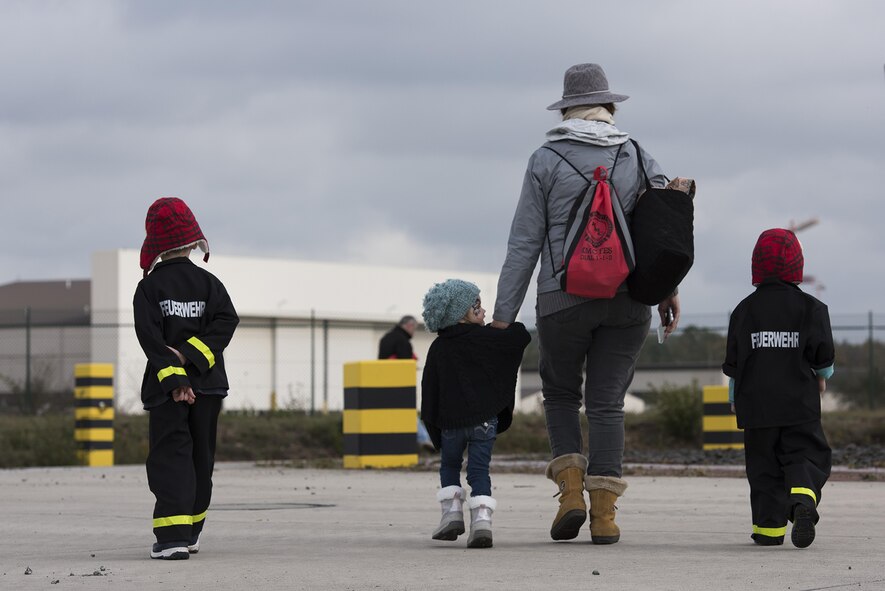 Members of the Kaiserslautern Military Community walk toward the fire protection aircraft trainer during the Fire Prevention Week open house at Ramstein Air Base, Germany, Oct. 7, 2017. The simulator is used by fire fighters to practice putting out fires on a simulated aircraft. Fire Departments from Ramstein Village, Landstuhl, Carlsberg, and Technical Relief Foundation (THW) Kaiserslautern, participated in the parade and open house. (U.S. Air Force photo by Airman 1st Class Devin M. Rumbaugh)