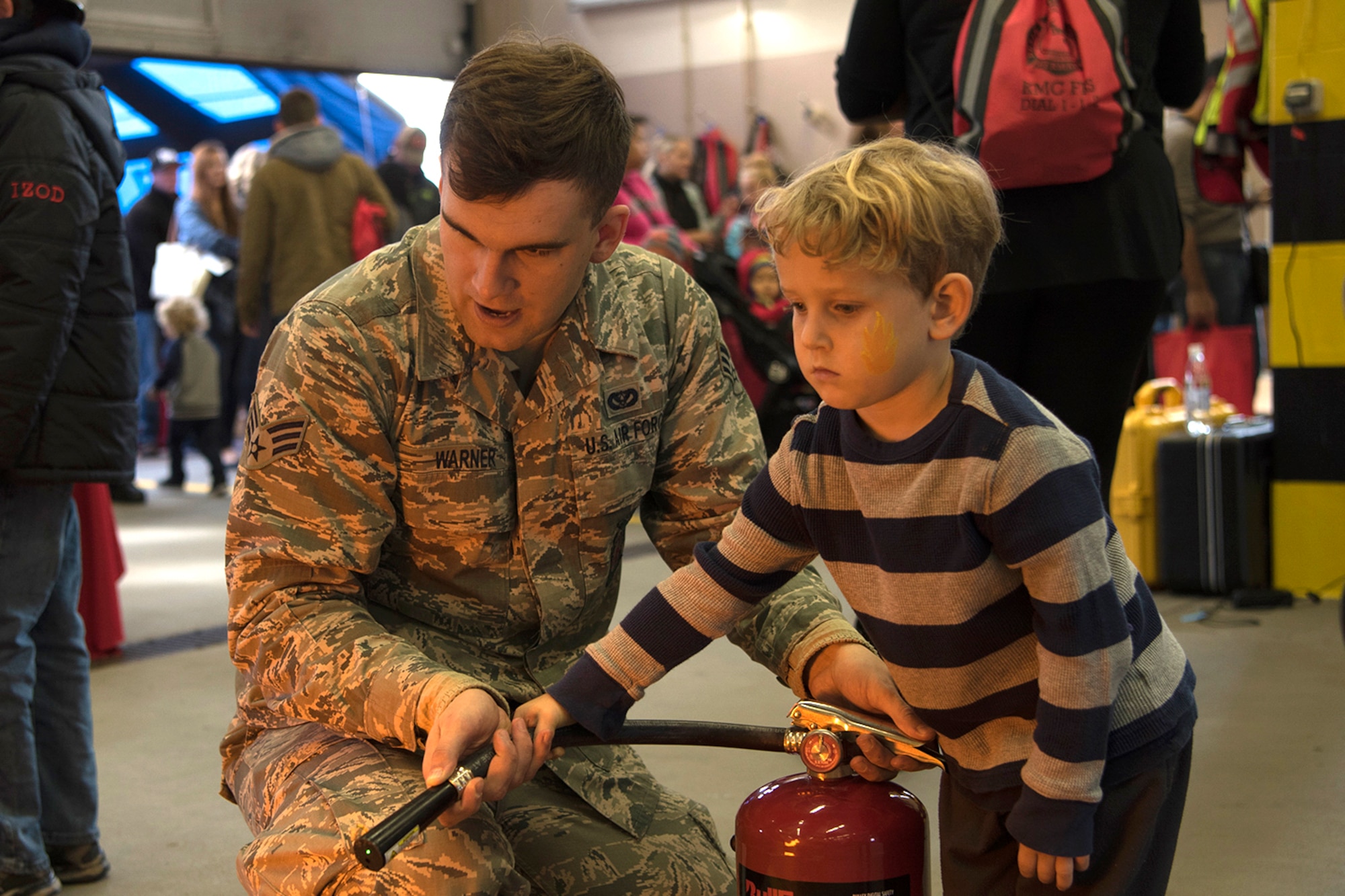 U.S. Air Force Senior Airman Seth Warner, 86th Civil Engineer Squadron driver operator, helps a child from the Kaiserslautern Military Community put out a simulated fire during the Fire Prevention Week open house on Ramstein Air Base, Germany, Oct. 7, 2017. Fire Departments from Ramstein Village, Landstuhl, Carlsberg, and Technical Relief Foundation (THW) Kaiserslautern, participated in the parade and open house. This year’s theme, “Every second counts, plan two ways out!” encourages families to have more than one exit plan in case of an emergency. (U.S. Air Force photo by Airman 1st Class Devin M. Rumbaugh)
