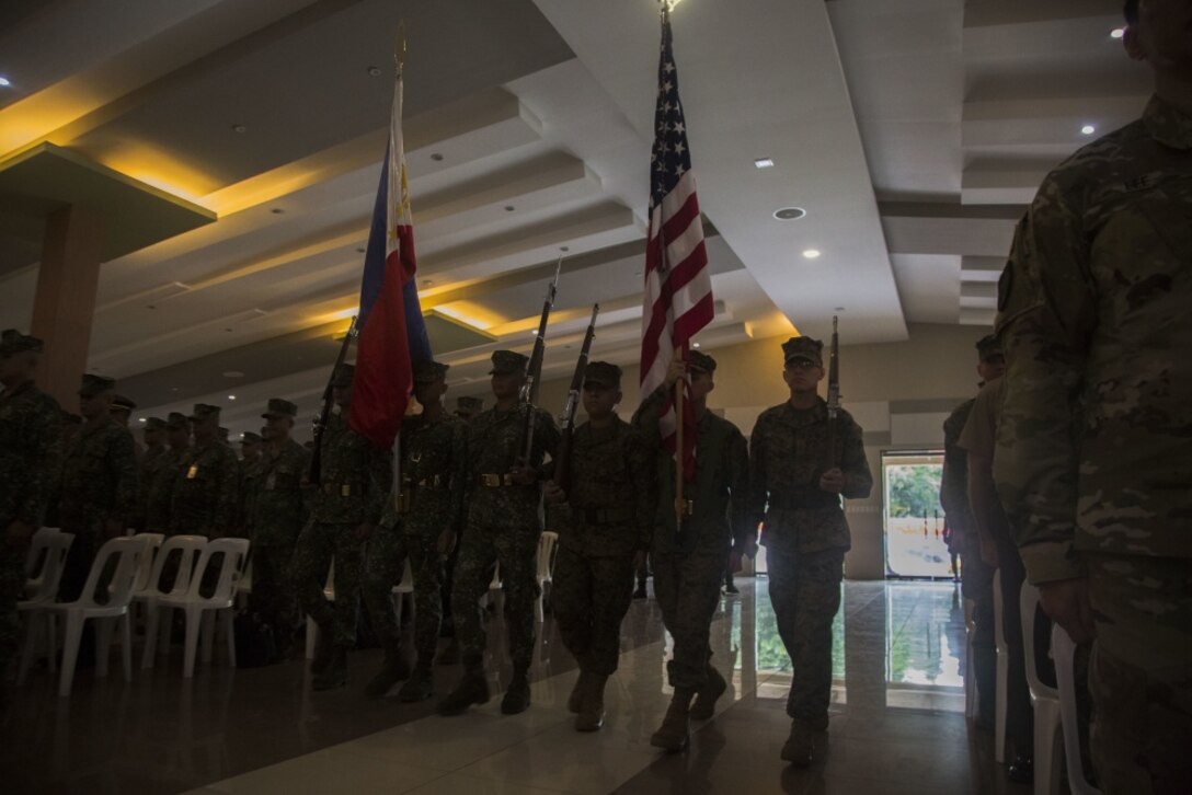 A color guard comprised of U.S. and Philippine Marines present their national colors at Marine Barracks Rudiardo Brown, Taguig, Philippines, Oct. 2, to celebrate the beginning of KAMANDAG. KAMANDAG is an acronym for the Filipino phrase "Kaagapay Ng Maddirigma Ng Dagat," which translates to "Cooperation of Warriors of the Sea." This bilateral exercise increases the ability of the U.S. and the Philippines to rapidly respond to terrorist threats or humanitarian crises. (U.S. Marine Corps Photo by Lance Cpl. Nathan Maysonet)