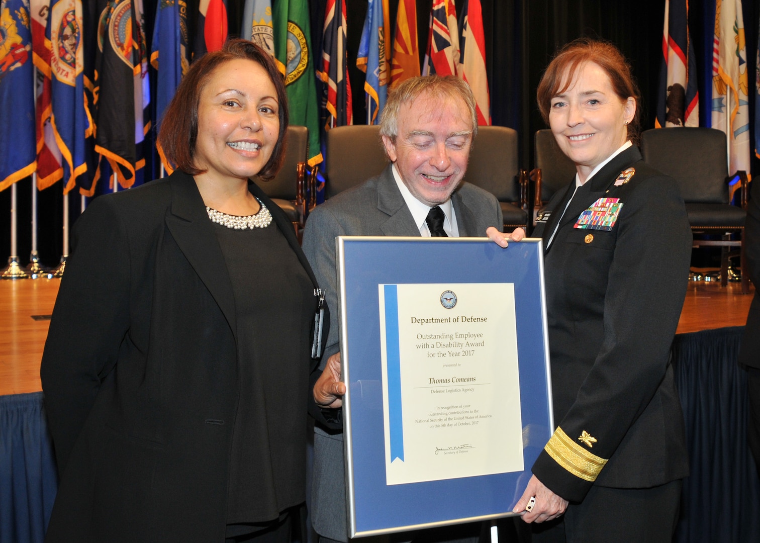 Three persons facing viewer, with framed certificate