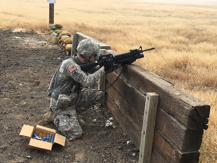 Army Capt. Derek Derkacs fires an M203 grenade launcher during the Idaho Army National Guard's annual training.