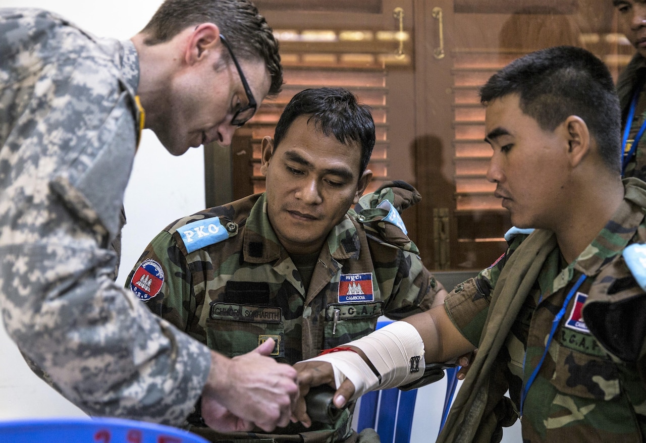 Army Capt. Derek Derkacs explains to members of the Royal Cambodian Armed Forces how to splint a fracture.