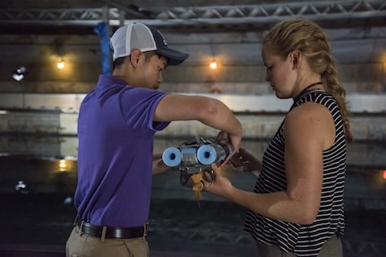 Student interns currently assigned to Naval Surface Warfare Center, Carderock Division under the Science and Engineering Apprenticeship Program make last-minute adjustments to their 3-D printed boat Host and Swarm Ocean Cleaning Vessel just before the second annual Additive Manufacturing (AM) Challenge in West Bethesda, Md., Aug. 10, 2017. These students designed and created additively manufactured boats using a standard kit of parts and raced them in the David Taylor Model Basin to complete the event, which is sponsored by the Naval Sea Systems Command 05 Chief Technology Office. (U.S. Navy photo by Dustin Q. Diaz/Released)