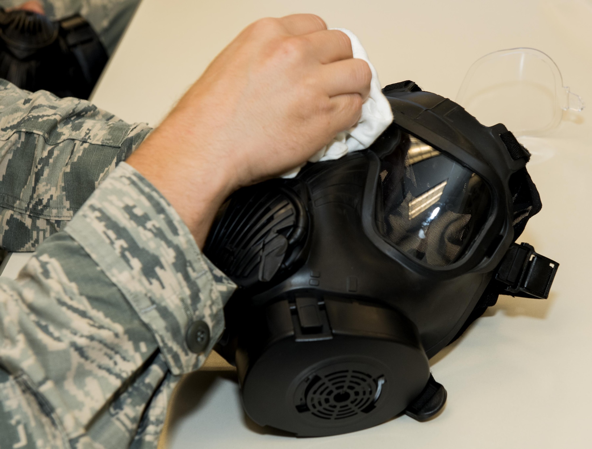 U.S. Air Force Airman cleans the plastic eye piece of a gas mask during a chemical, biological, radiological and nuclear defense survival skills training course on Travis Air Force Base, Calif., Sep. 21, 2017. CBRN defenses are protective measures taken in situations in which chemical, biological, radiological or nuclear warfare (including terrorism) hazards may be present. CBRN defense consists of CBRN passive protection, contamination avoidance and CBRN mitigation. (U.S. Air Force photo by Heide Couch)