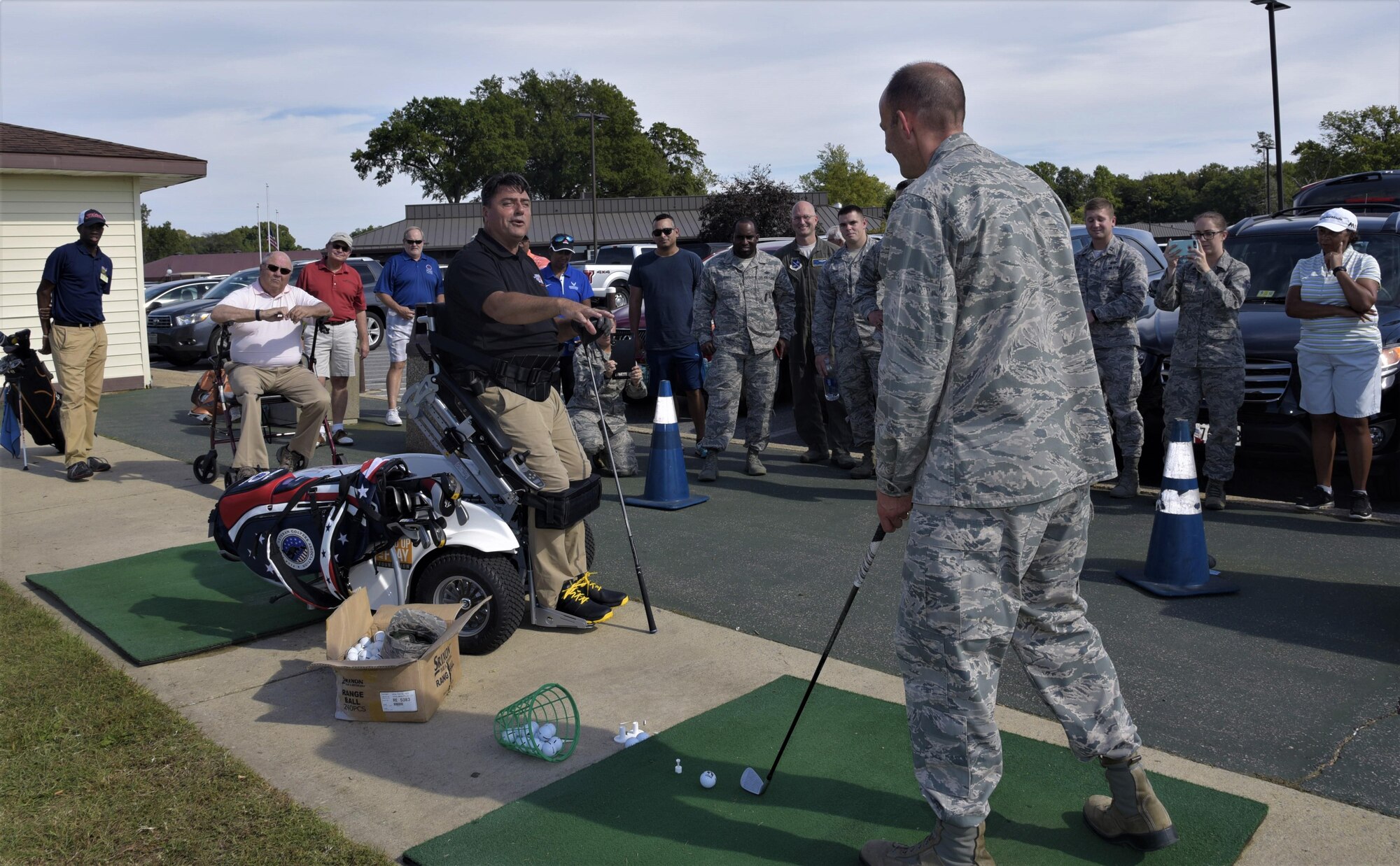 Col. E. John Teichert, right, 11th Wing and Joint Base Andrews commander, receives coaching from Anthony Netto, Stand Up and Play Foundation founder, at Joint Base Andrews, Md., Oct. 6, 2017. Netto came to JBA to demonstrate how to golf while secured to a wheelchair specially designed to enable paralyzed persons to stand up.