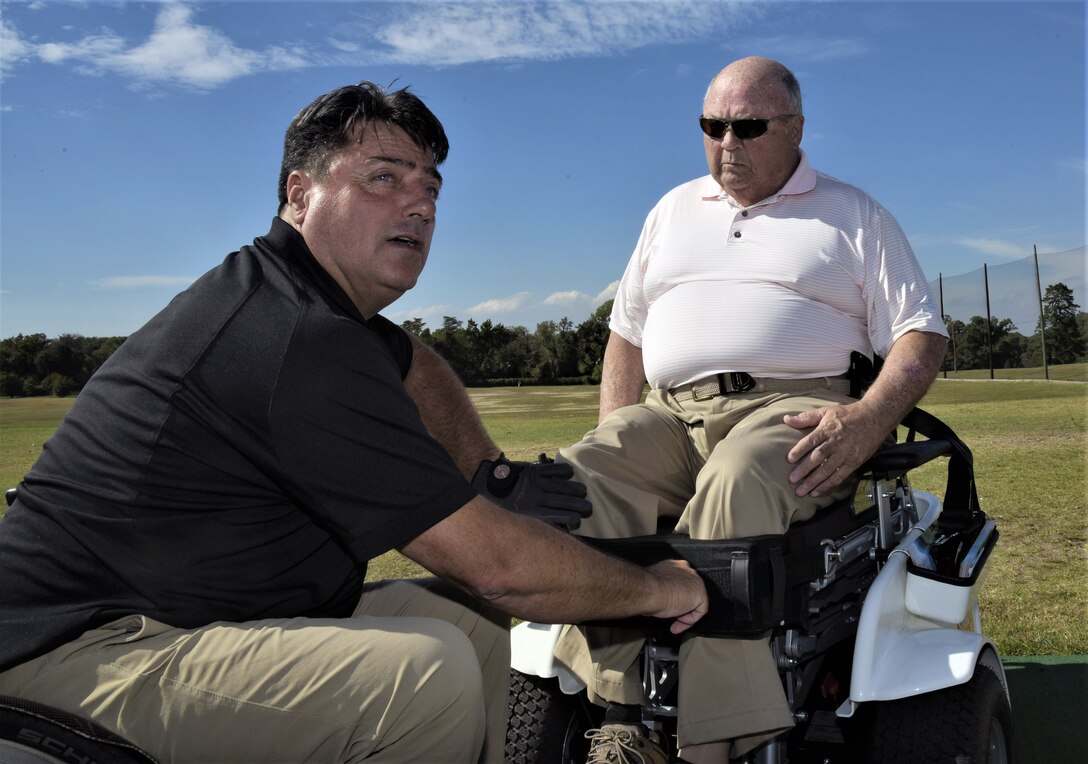 Anthony Netto, left, Stand Up and Play Foundation founder, secures Hon. John Farley, four-time Bronze Star recipient and Vietnam War veteran, into a Paramobile golf cart at Joint Base Andrew, Md., Oct. 6, 2017. Farley is a lower-limb amputee resulting from an injury he sustained in combat. The Paramobile is a specially designed wheelchair that enables paralyzed persons to stand up for activities such as swinging a golf club.