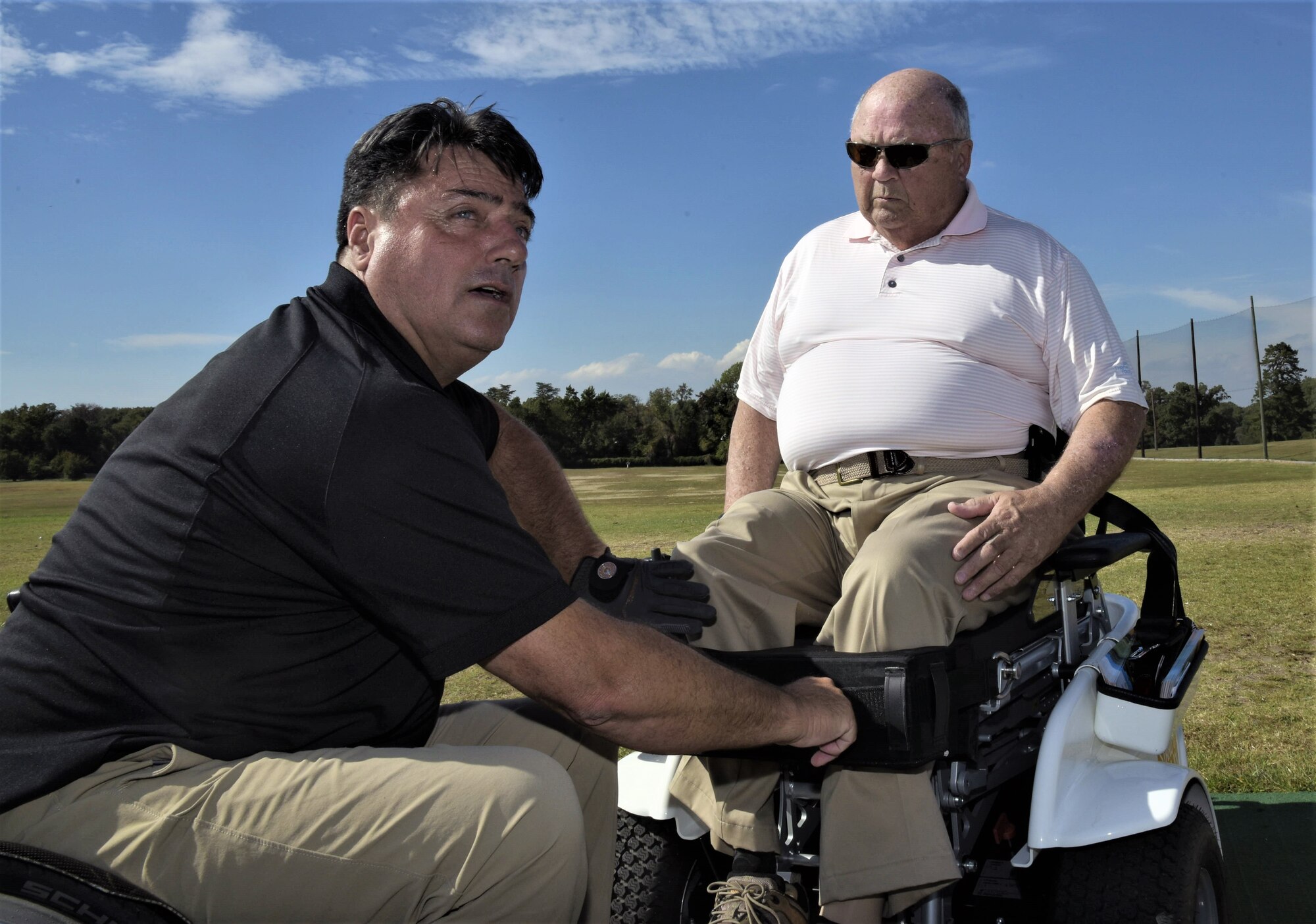 Anthony Netto, left, Stand Up and Play Foundation founder, secures Hon. John Farley, four-time Bronze Star recipient and Vietnam War veteran, into a Paramobile golf cart at Joint Base Andrew, Md., Oct. 6, 2017. Farley is a lower-limb amputee resulting from an injury he sustained in combat. The Paramobile is a specially designed wheelchair that enables paralyzed persons to stand up for activities such as swinging a golf club.
