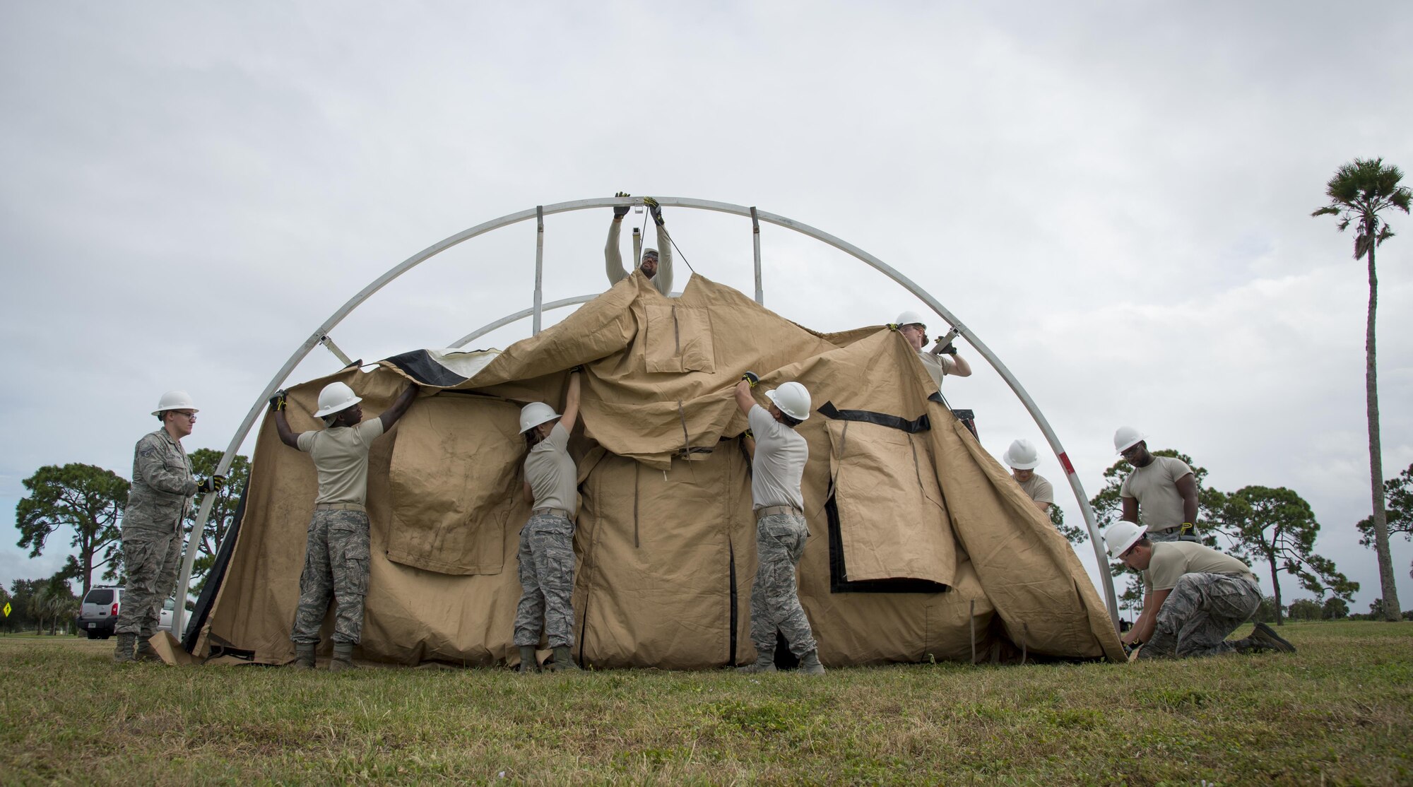 Services Airmen assigned to the 6th Force Support Squadron, put a tent covering over the structure of a Small Shelter System during Home Station Training at MacDill Air Force Base, Fla., Oct. 5, 2017. The Small Shelter System is a tent used for lodging and can also be used as a fitness or recreation tent. (U.S. Air Force photo by Senior Airman Mariette Adams)