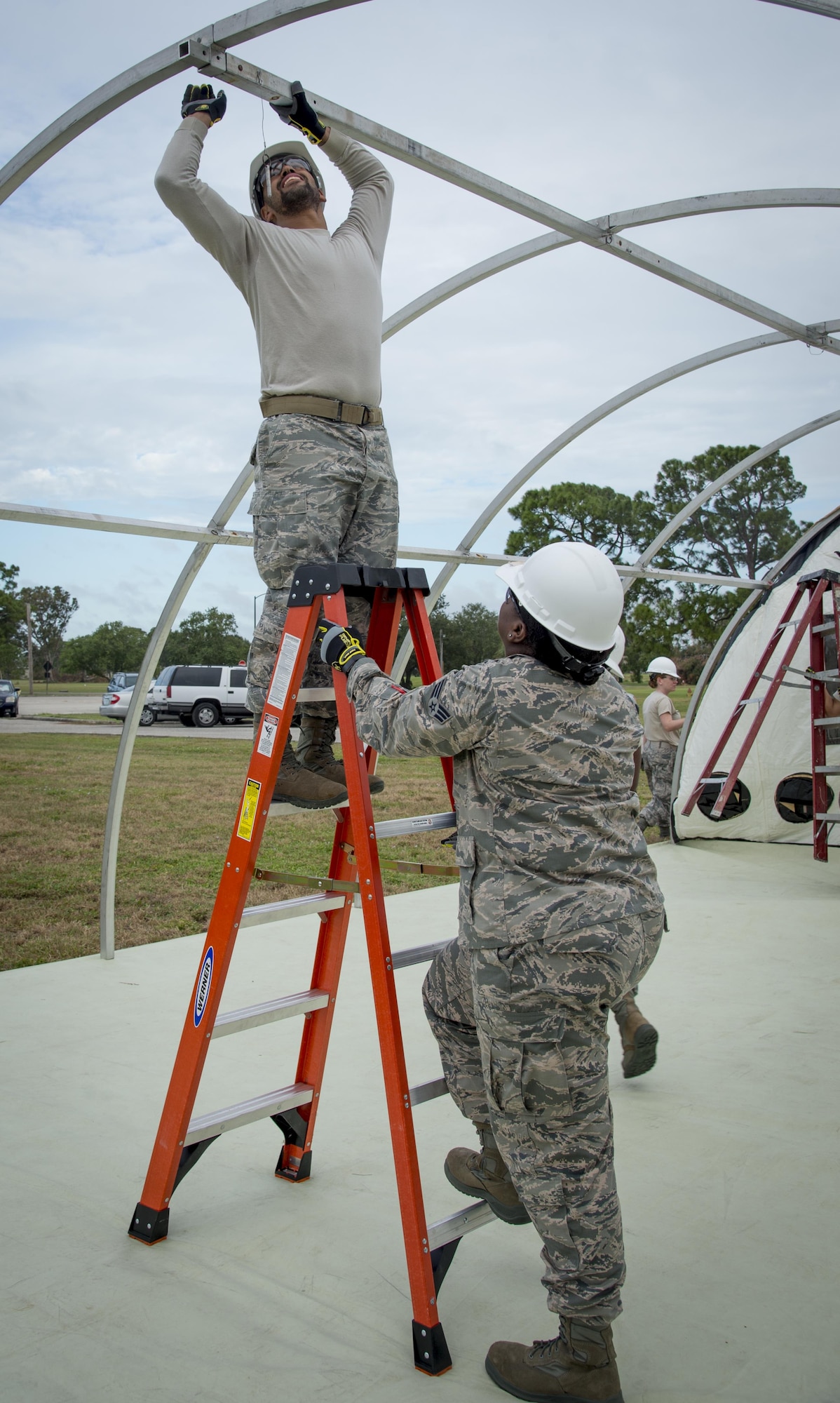 Services Airmen assigned to the 6th Force Support Squadron, remove the supporting structure of the Small Shelter System in order to put the tent away during Home Station Training at MacDill Air Force Base, Fla., Oct. 5, 2017. During the two-day course, they work with two types of tents, the Temper Tent and the Small Shelter System. (U.S. Air Force photo by Senior Airman Mariette Adams)