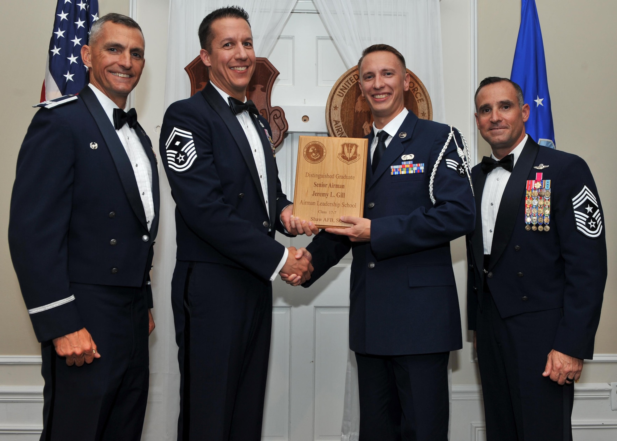 U.S. Air Force Senior Airman Jeremy Gill, 609th Air Communications Squadron, receives a Distinguished Graduate Award from Senior Master Sgt. Keith Rivers of the Shaw Diamond Council, during the Senior Master Sgt. David B. Reid Airman Leadership School Class 17-7 graduation ceremony at Shaw Air Force Base, S.C., Oct. 6, 2017.