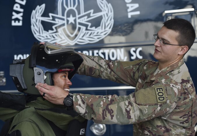 Staff Sgt. Kyle Bushey, 628th Civil Engineer Squadron explosive ordnance disposal technician, helps Naiyeda Perez, left, Jenkins High School Navy Junior Reserve Officer Training Corps member, Savannah, Georgia, don an EOD suit during Joint Base Charleston’s annual Career Day here Oct. 11, in South Carolina. Junior ROTC units attended Career Day to get a closer look at what it's like to serve in the U.S. Military. Career Day is a way for the base to connect with young, and possible future service members in the community. Approximately 250 Junior JROTC cadets had the opportunity to have a face-to-face interaction with service members representing the U.S. Army, U.S. Marine Corps, U.S. Navy, U.S. Air Force and U.S. Coast Guard.