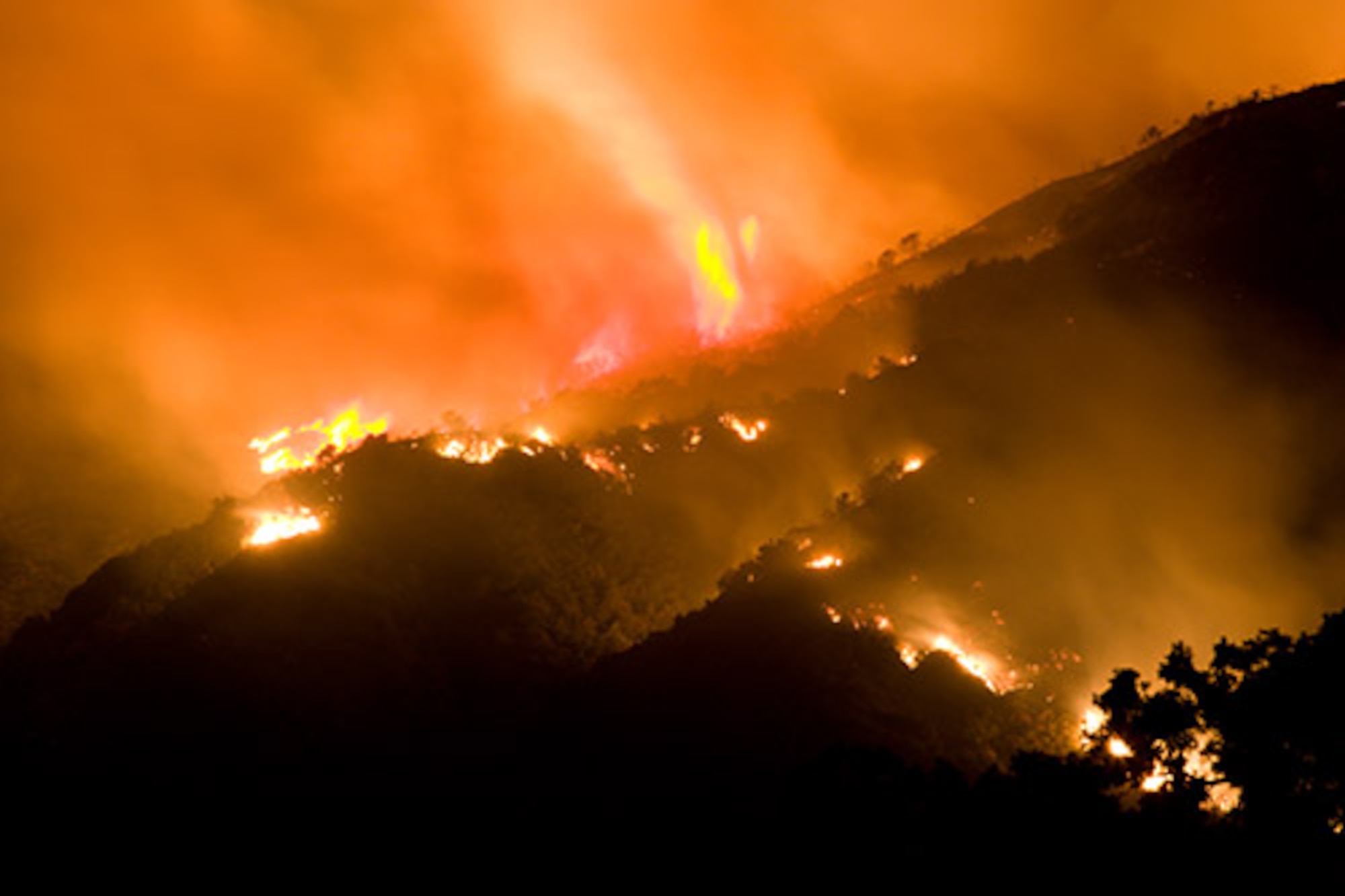 Flames and glow from out of control wildfire with large swirl of flame in Napa County, Calif., Oct. 10, 2017. Active wildfires in California have burned an estimated 1,500 homes and commercial structures, scorched more than 115,000 acres and reportedly killed 15 people.