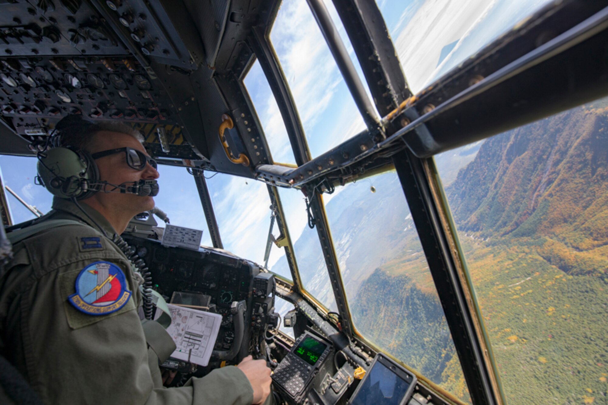 Capt. Thomas Bernard, 36th Airlift Squadron C-130H pilot, performs visual confirmation during a tactical training sortie, over Yamanashi Prefecture, Japan, Oct. 5, 2017. This is the last active duty C-130H Hercules tactical training sortie.