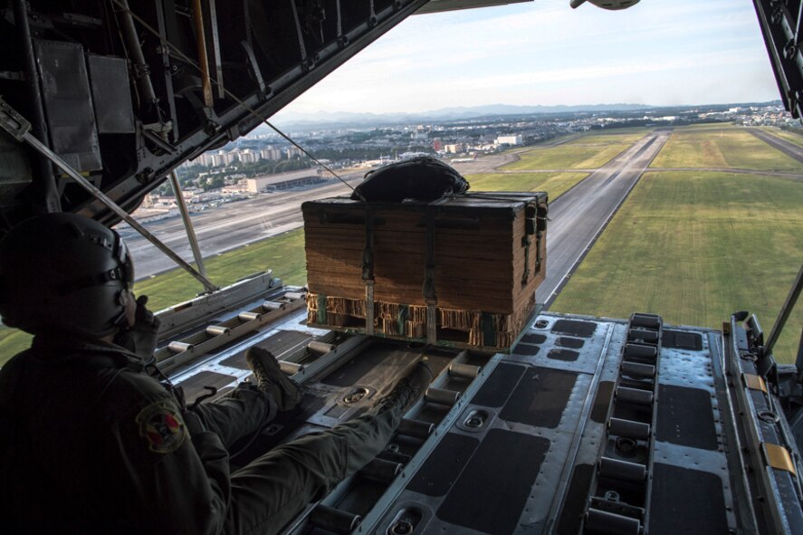 Senior Airman Gary Coe, 36th Airlift Squadron C-130H loadmaster, drops a low-cost, low-altitude bundle over Yokota Air Base, Japan, Oct. 5, 2017. This is the last time active duty C-130H Hercules' crew members perform an LCLA airdrop.