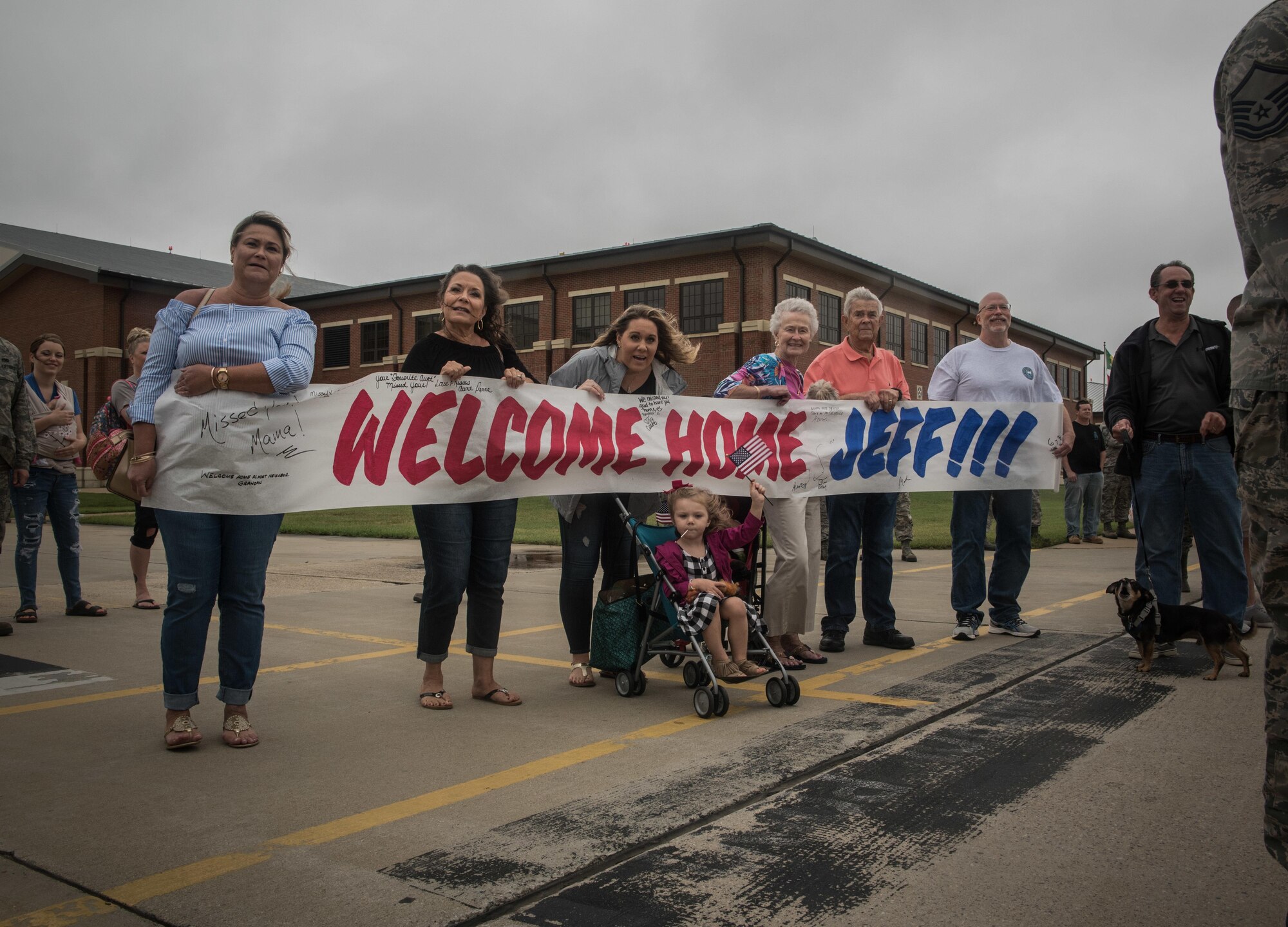 Family of Virginia Air National Guard Staff Sgt. Jeff Greenquist, holds a welcome home sign, celebrating his return from the Middle East at Joint Base Langley- Eustis, Va., Oct. 12, 2017. Greenquist is a low observable technician from the 192nd Maintenance Squadron and was deployed with the 1st Fighter Wing for six months. The deployment consisted of F-22 Raptors and Airmen representing the 1st FW in Operation Inherent Resolve against ISIS. (U.S. Air Force photo by Staff Sgt. Carlin Leslie)