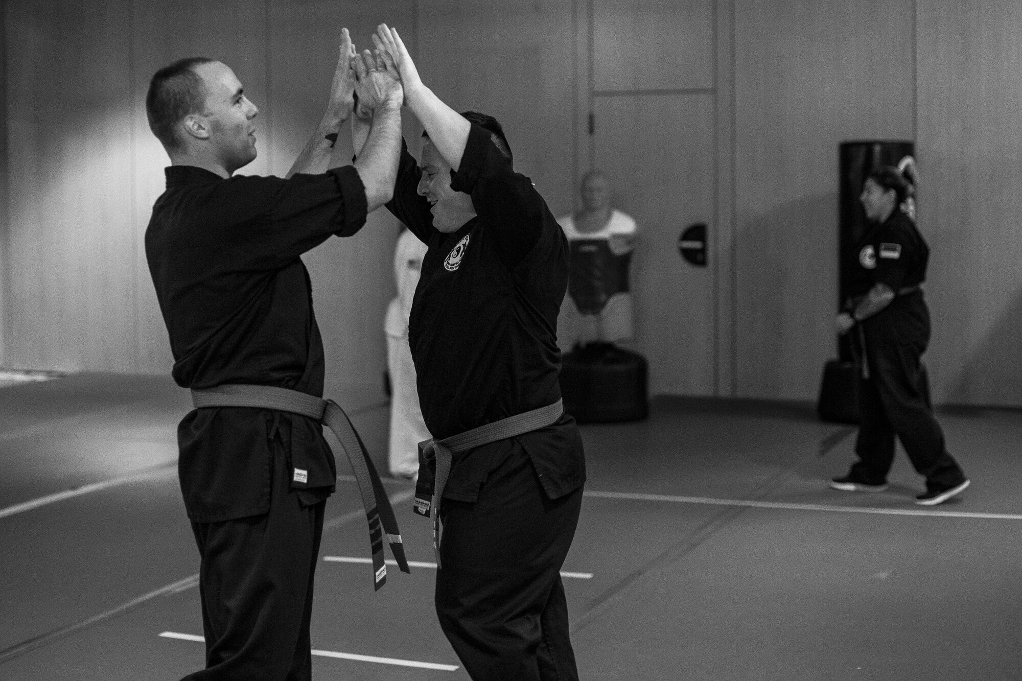 U.S. Air Force Staff Sgt. Brandon Sabin, 86th Airlift Wing Public Affairs broadcast journalist, and U.S. Army Staff Sgt. Michael Decker, clap hands after practicing a form during a mixed martial arts class at the Vogelweh Community Center on Vogelweh Military Complex, Germany, Oct. 11, 2017. Sabin explained, in martial arts everyone wants each other to succeed so they work together to help each person grow. (U.S. Air Force photo by Senior Airman Devin Boyer)