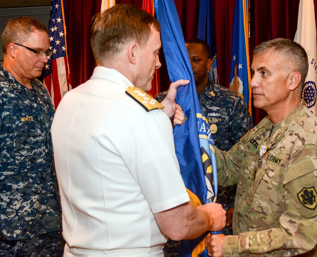 Navy Adm. Michael S. Rogers, Commander, USCYBERCOM, center, takes the unit colors from Army Maj. Gen. Paul Nakasone during the Cyber National Mission Force change of command ceremony here Sept. 20, 2016. Navy Rear Adm. T. J. White, left, waits to officially take command of the unit. Nakasone was the second commander of the CNMF and will become the commander of Army Cyber Command