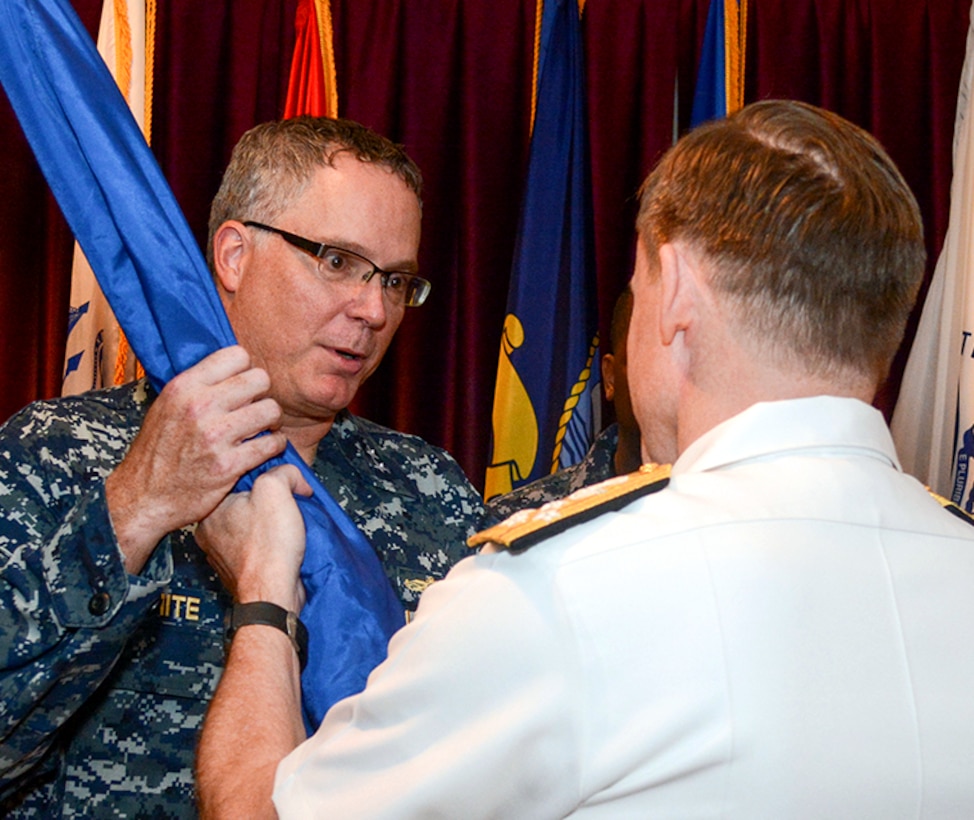 Navy Rear Adm. T. J. White, left, takes the unit colors from Adm. Michael S. Rogers, Commander, USCYBERCOM, to become the third commander of the Cyber National Mission Force. The CNMF plans, directs and synchronizes full-spectrum cyberspace operations to deter, disrupt, and if necessary, defeat adversary cyber actors to defend the nation.