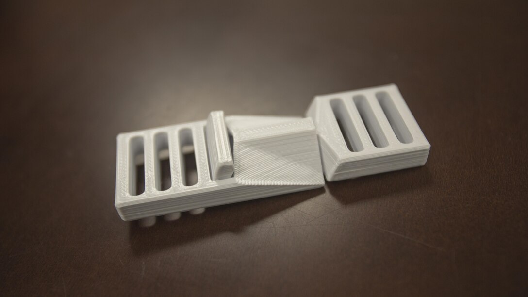 Buckled pack clips from 2nd Battalion, 8th Marine Regiment’s 3-D printer at Camp Lejeune, N.C., Oct. 6, 2017. 2/8 is the first infantry battalion in the United States Marine Corps to utilize a 3-D printer to ensure battalion readiness in the event of equipment malfunctions. (U.S. Marine Corps photo by Lance Cpl. Ashley McLaughlin)