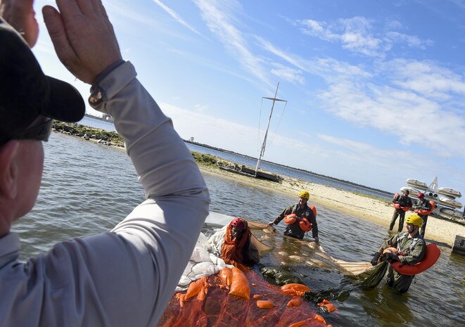 Tech. Sgt. Alan Morse, 437th OSS survival, evasion, resistance and escape NCO in charge demonstrates the proper technique for getting out from under a parachute while in water Oct. 2, 2017.