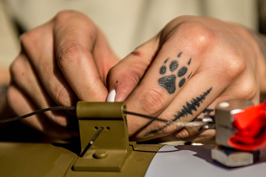 An Airman assigned to the 310th Aircraft Maintenance Unit prepares a GBU-12 Paveway II bomb during the 56th Fighter Quarterly Load Crew competition at Luke Air Force Base, Ariz., Oct. 6, 2017.  Though several tools are used to load munitions, often times Airmen have to use their hands for meticulous tasks. (U.S. Air Force photo/SSgt Jensen Stidham)