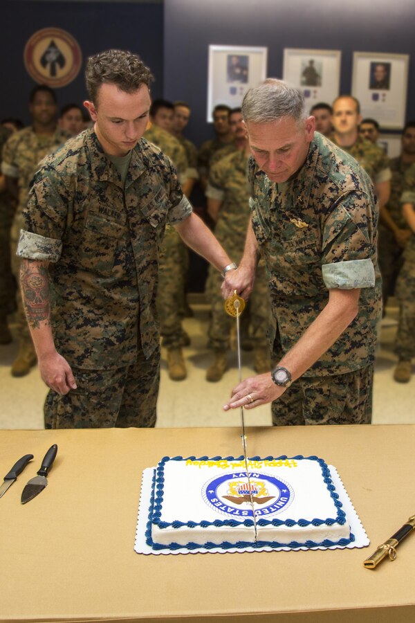 The most junior and senior Sailors, a 20-year-old hospitalman with Marine Raider Support Group, and Cmdr. Mark S. Winward, 57-year-old command chaplain for U.S. Marine Corps Forces, Special Operations Command,  use a Naval Officer's Sword to make the ceremonial first cut of the a birthday cake honoring the Navy’s 242nd birthday at MARSOC Headquarters on Camp Lejeune, N.C., Oct. 13, 2017. (U.S. Marine Corps photo by Sgt. Salvador R. Moreno/Released)